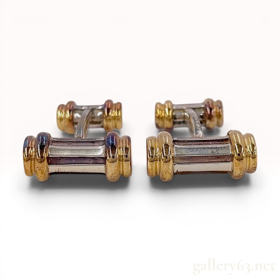 Sterling Silver and 18KYG Tiffany and Co. Barbell Cufflinks: A pair of authentic Tiffany and Co. barbell-style cufflinks featuring a mixed-metal construction. Each piece consists of a curved central bridge in sterling silver connecting two cylindrical terminals