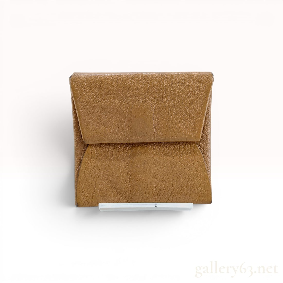 Hermes Bastia Verso Grained Leather Coin Purse: An authentic Hermes Bastia Verso coin purse constructed from a single piece of folded grained leather. The design features a tan exterior with a contrasting light pink interior. The purse is secured b