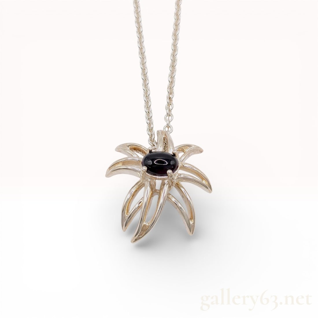 Tiffany and Co. Sterling Silver and Black Onyx Fireworks Pendant Necklace: Tiffany and Co. Fireworks pendant necklace, dated 1995. The sterling silver pendant features an abstract sculptural form with ten radiating arms centering a four-prong set oval black onyx cabochon. It