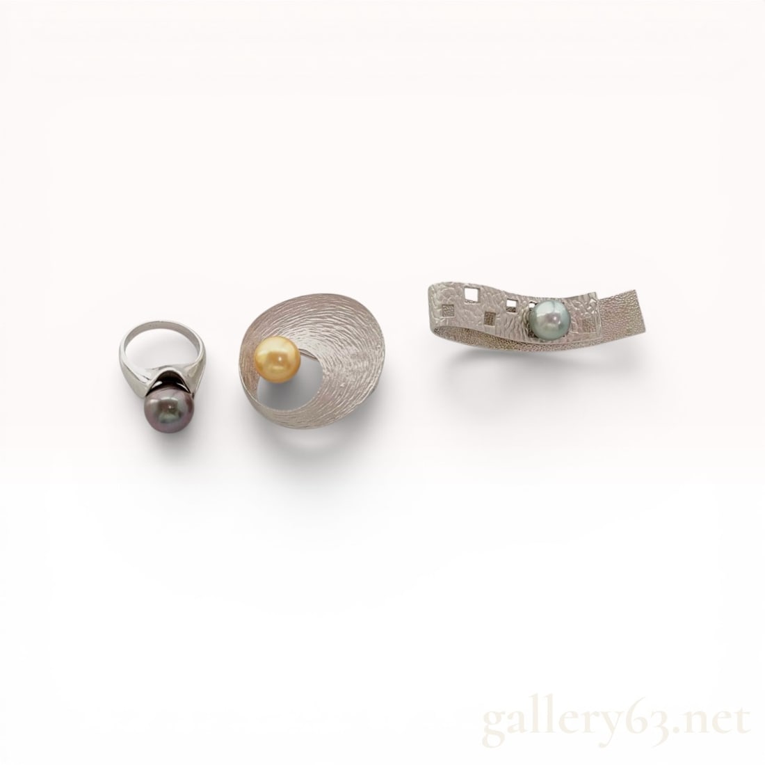 A Trio of Modernist Cultured Pearl and Sterling Silver Jewelry: This collection includes a bypass-style ring and two abstract brooches featuring cultured pearls set in silver and silver-toned metal. The ring contains a 10mm dark gray iridescent pearl, while the br