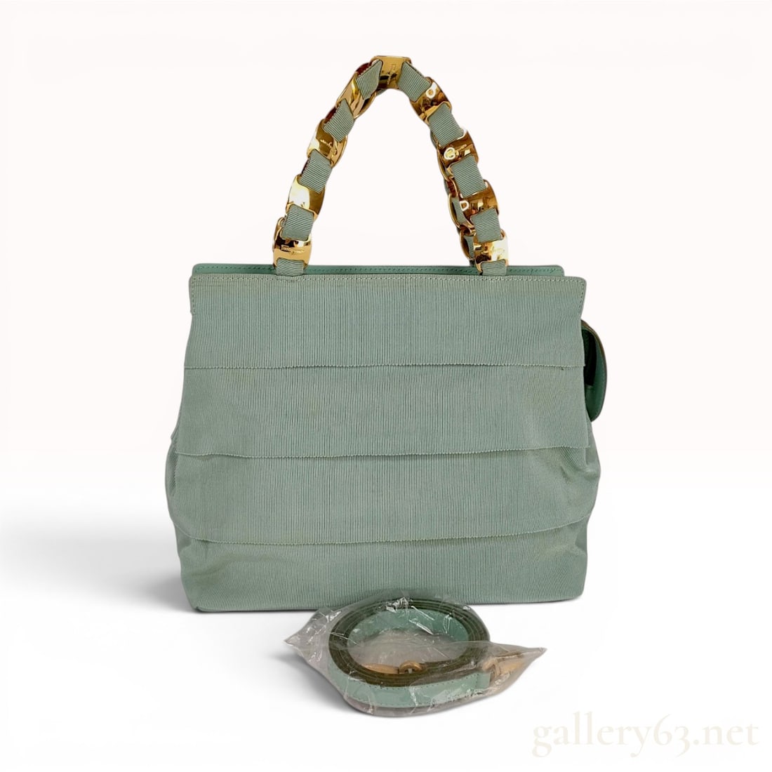 Salvatore Ferragamo Mint Green Tiered Grosgrain Ribbon Top Handle Bag: A Salvatore Ferragamo top handle bag featuring an exterior of horizontal tiered ruffles in mint green grosgrain ribbon. The bag is constructed with a matching smooth leather base and gold-toned hardwa