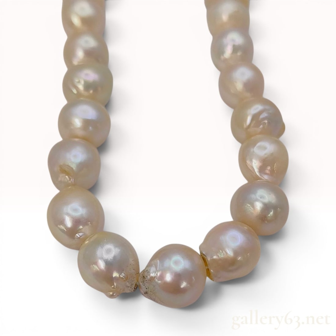 Cultured Semi-Round Pearl Necklace with Floral Silver Clasp: A single-strand necklace featuring approximately 47 cultured pearls of semi-round shape. The pearls measure approximately 8.8 to 9.6 mm in diameter and display a creamy-white body color with pinkish o