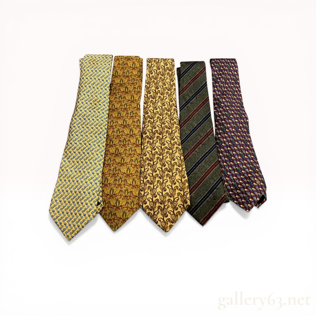 A Group of Five Designer Silk Neckties Including Dunhill and Salvatore Ferragamo: A group of five designer silk neckties featuring pieces by Salvatore Ferragamo and Dunhill. The collection includes various printed patterns such as camels, rocking horses, foliate scrolls with crests