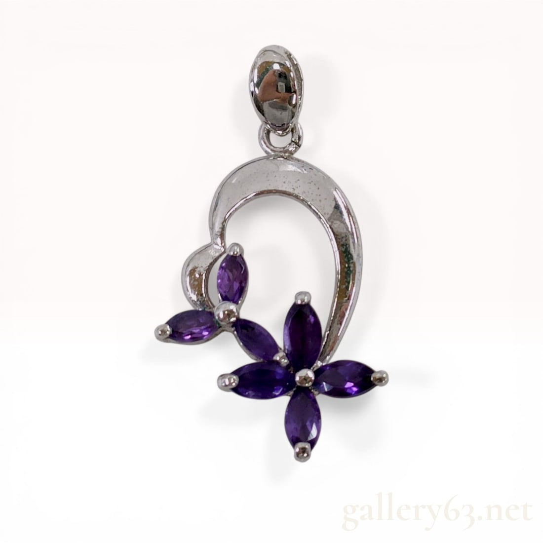 Sterling Silver and Marquise Amethyst Flower Pendant: Sterling silver open-work pendant featuring two floral motifs set with six marquise-cut purple gemstones. The design consists of a polished crescent-shaped frame with prong-set stones and a tapered ba