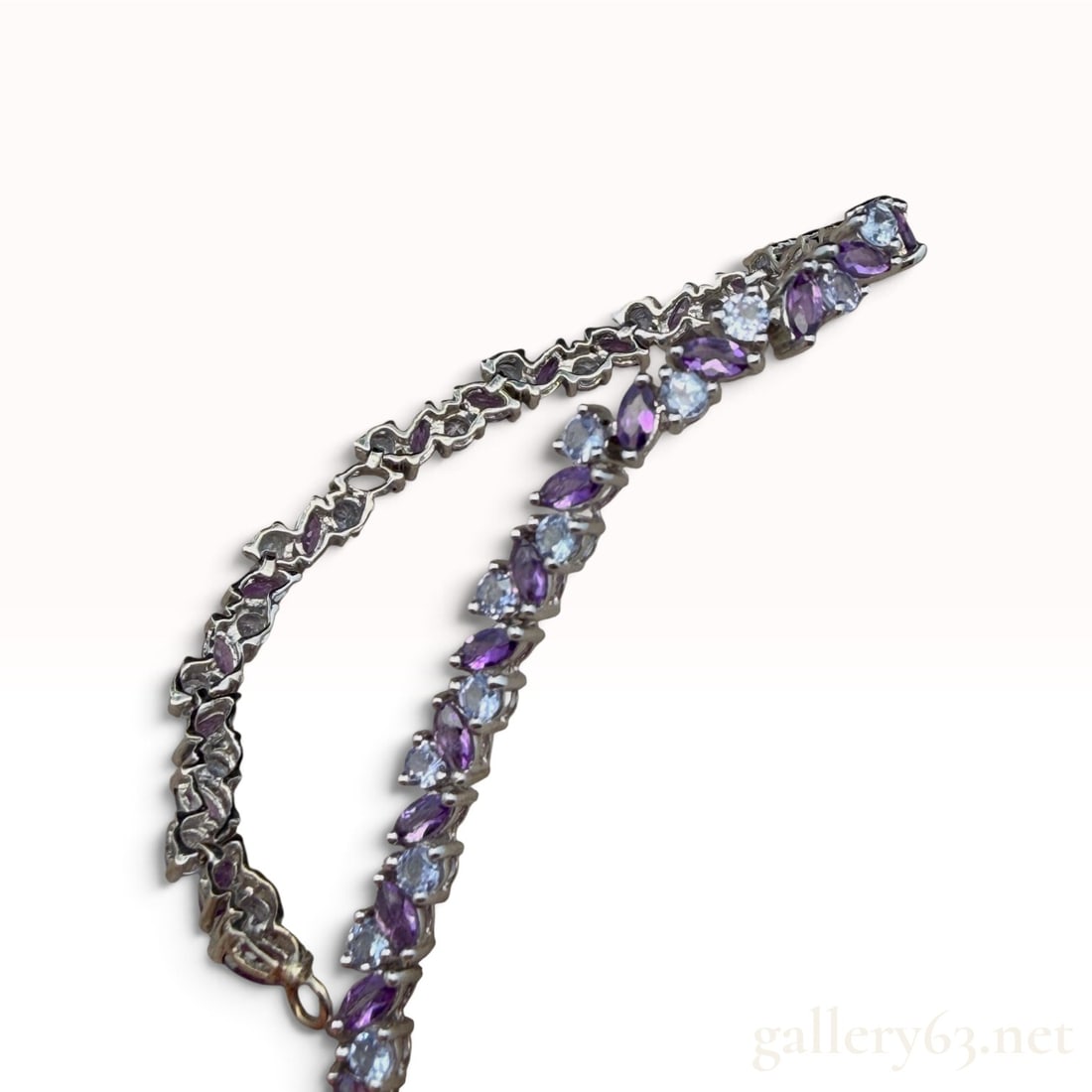 10k White Gold Amethyst and Topaz Bracelet: The lot features a 10k White Gold Amethyst and Topaz Bracelet with 7" length 7.2 grams. Approximately 2. 0.50 carat total weight gemstones. Please note that one stone needs replacement.
