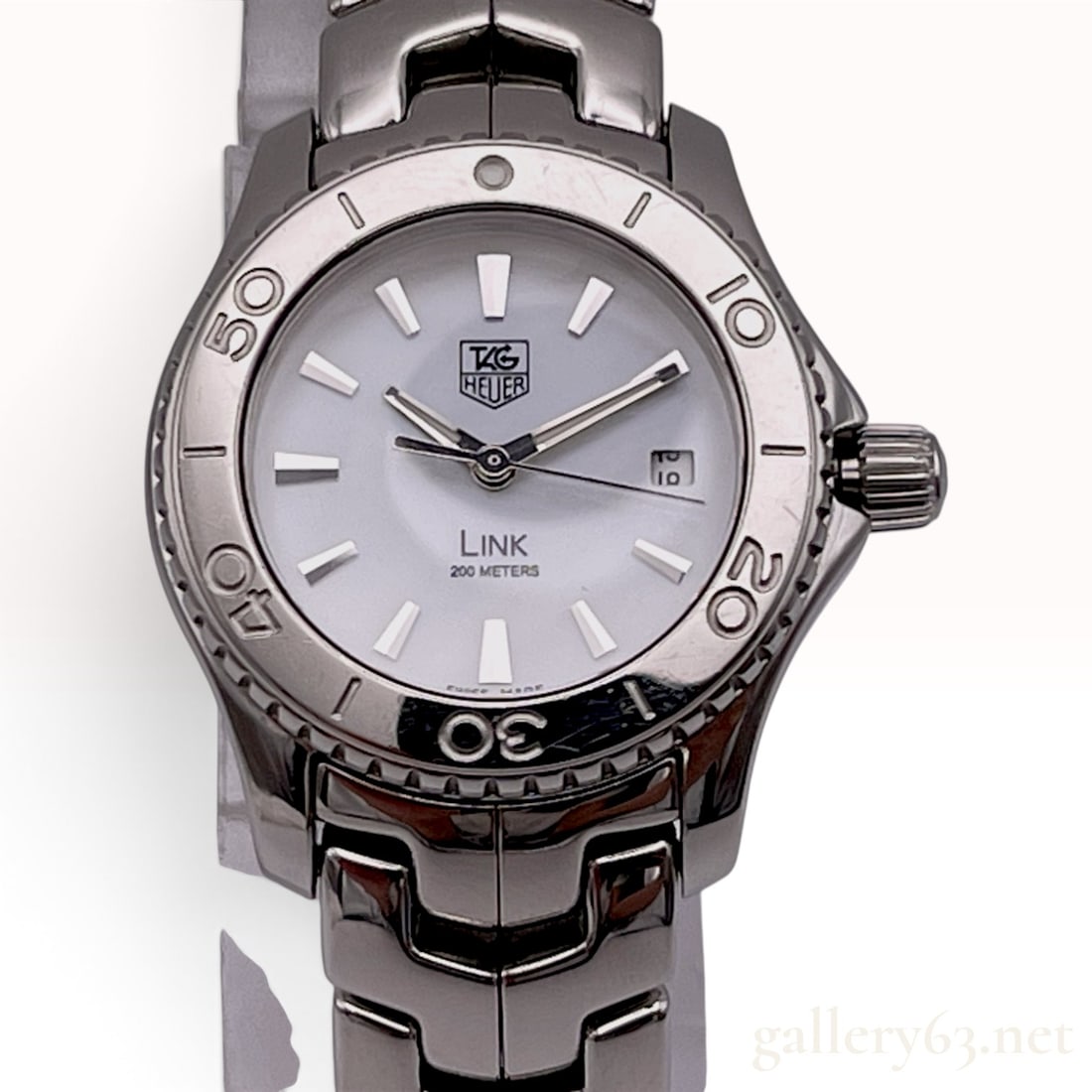TAG Heuer Link WJ1313 Stainless Steel Quartz Ladies Watch with Mother of Pearl Dial: A TAG Heuer Link ladies' wrist watch, reference number WJ1313, featuring a stainless steel case with a unidirectional rotating bezel. The dial is white mother of pearl set with applied silver-tone hou