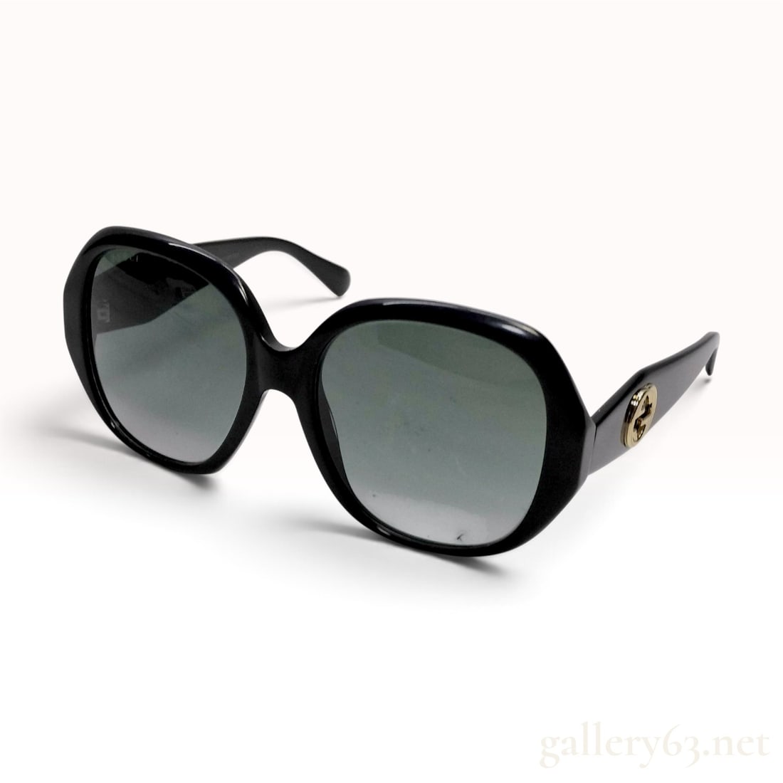 Gucci GG0796S Women's Oversized Square Sunglasses: A pair of Gucci women's oversized sunglasses, model GG0796S. The frames are constructed from black acetate in a rounded square silhouette, fitted with graduated gray lenses. Each temple features a