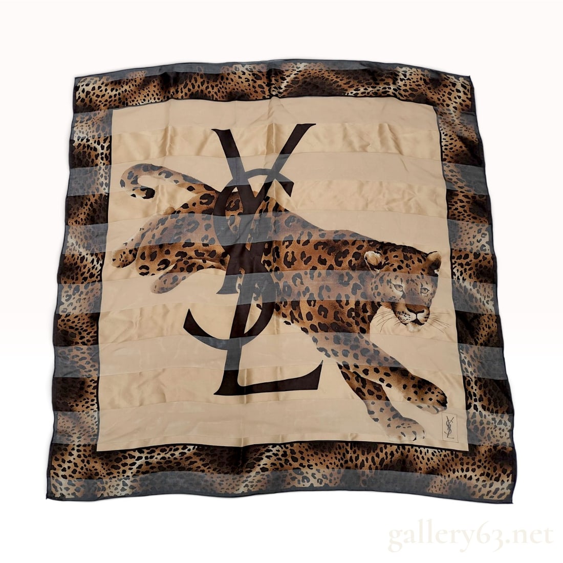 Yves Saint Laurent Silk Leopard Print and Monogram Carre Scarf: Square silk scarf by Yves Saint Laurent featuring a central graphic of a leaping leopard overlaid with a large translucent-effect interlocking YSL monogram. The composition includes alternating horizo