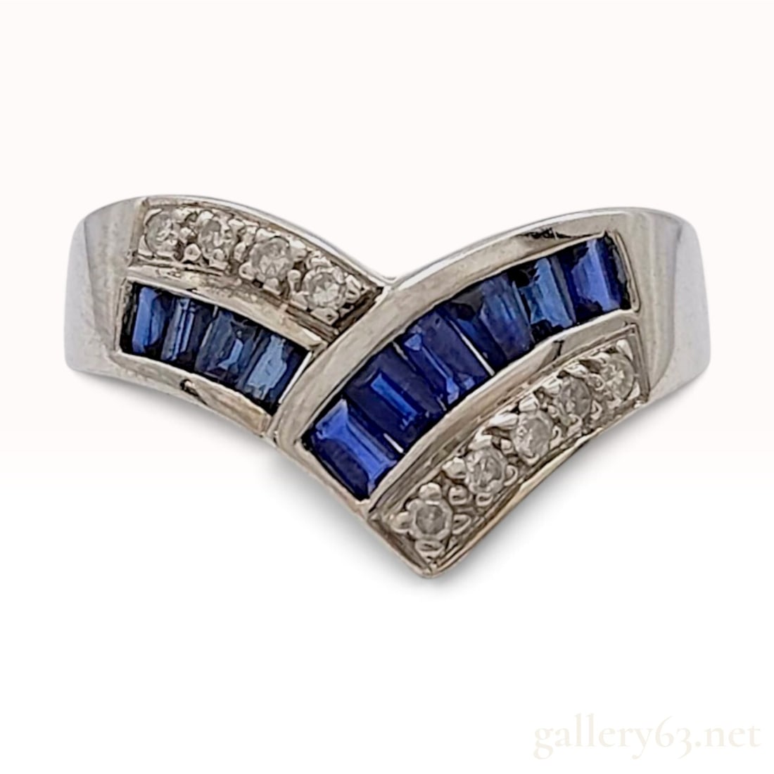 Miyako 14 Karat White Gold Sapphire and Diamond Chevron Ring: A 14 karat white gold fashion ring by the maker Miyako, designed in a v-shaped chevron style. The center of the ring features a channel-set row of ten baguette-cut blue sapphires totaling 1.00 carat. 