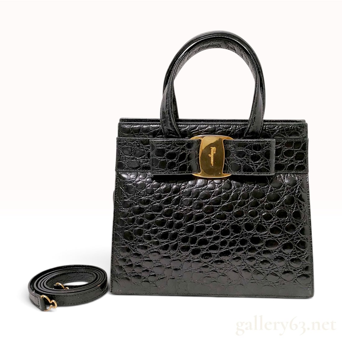 Salvatore Ferragamo Black Crocodile Embossed Leather Vara Bow Top Handle Bag: A structured Salvatore Ferragamo Vara Bow top handle handbag crafted from black crocodile-embossed leather. The front exterior features a matching leather Vara bow centered with a gold-tone buckle. Th