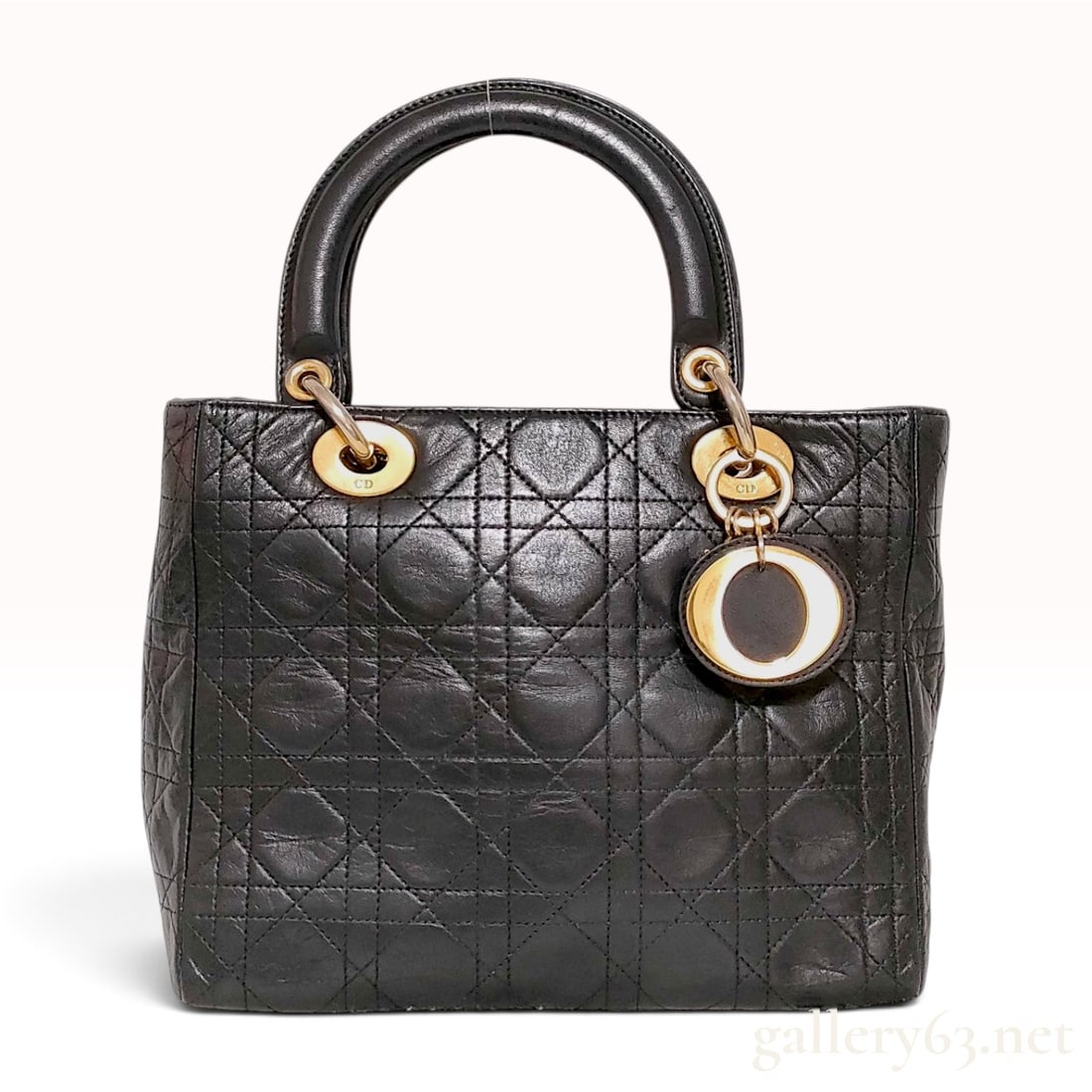Christian Dior Black Quilted Lambskin Medium Lady Dior Handbag: A Christian Dior Lady Dior medium sized handbag constructed from black lambskin leather featuring the signature Cannage quilted pattern. This structured piece is designed with dual rounded top handles