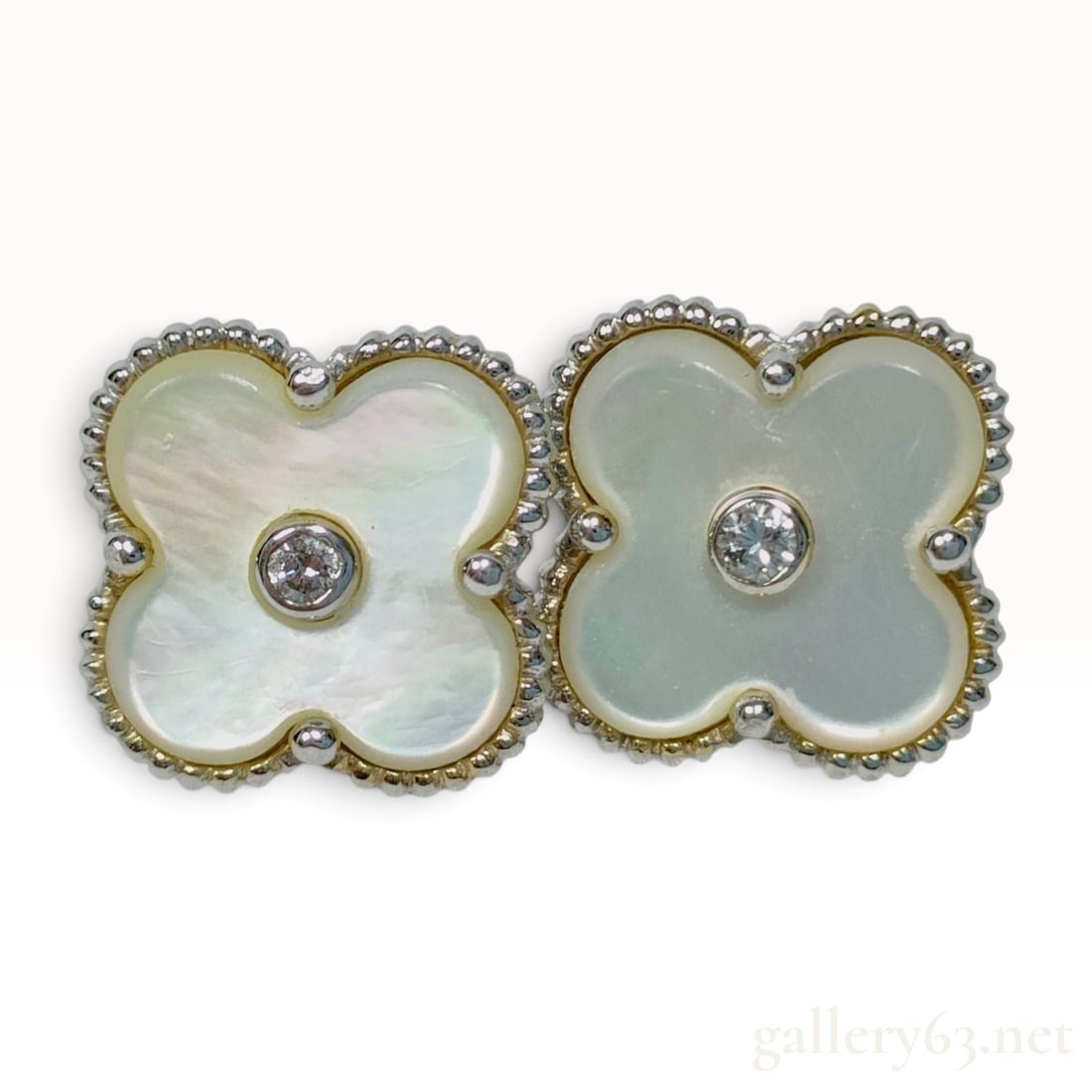 18KWG Mother of Pearl and Natural Diamond Quatrefoil Stud Earrings: A matched pair of quatrefoil stud earrings crafted from 18KWG with 18K yellow gold bezel accents. Each earring features a four-lobed mother-of-pearl inlay displaying a lustrous iridescence. A single r