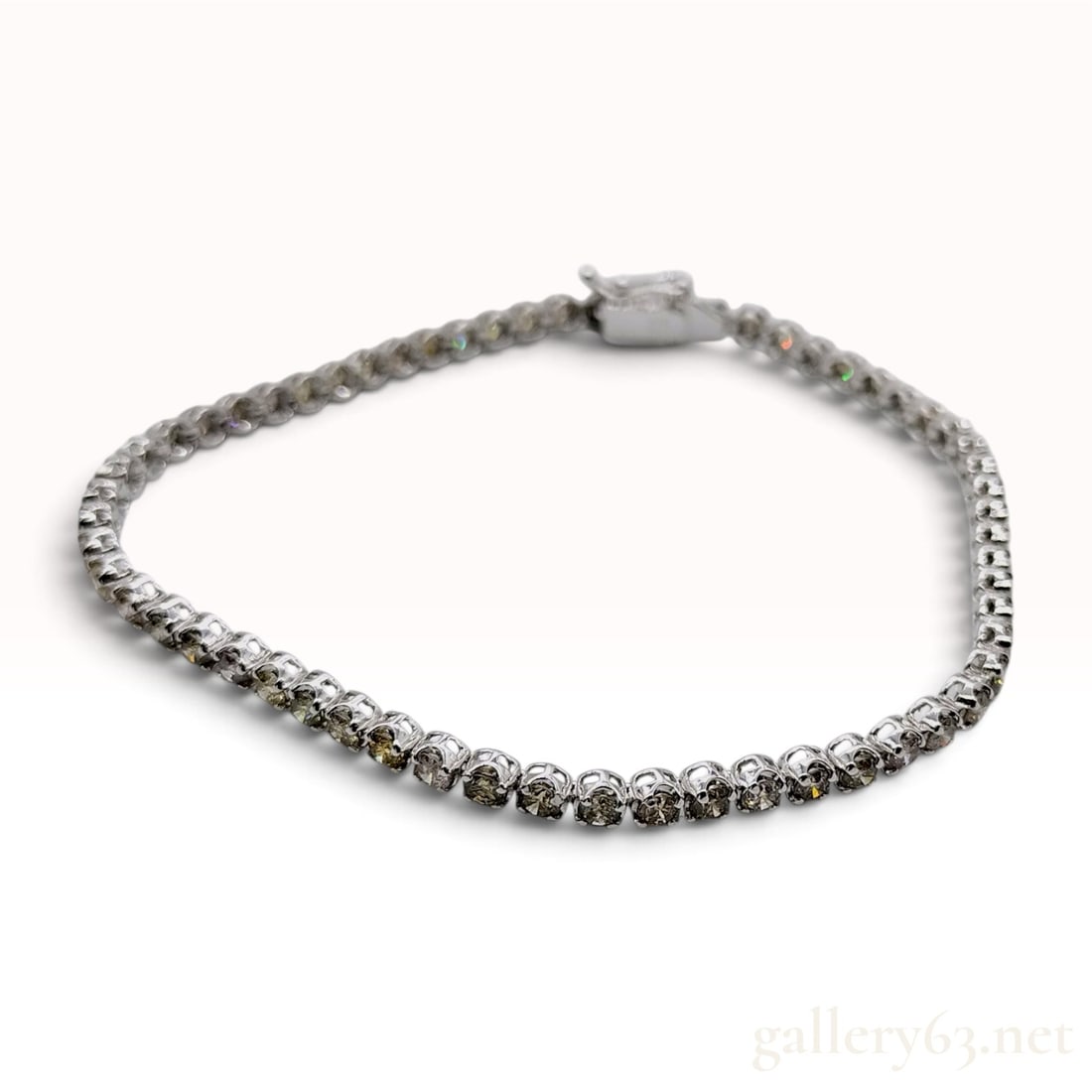 18K White Gold 3.00ctw Natural Diamond Tennis Bracelet: A fine jewelry tennis bracelet constructed of 18 karat white gold featuring a continuous line of round brilliant-cut natural diamonds. The stones exhibit a range of naturally occurring tints including