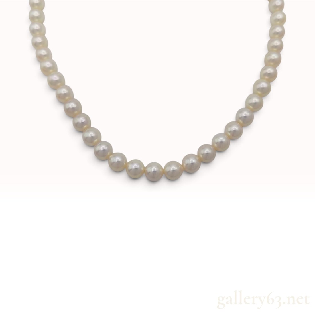 Graduated Cultured Pearl Choker Necklace with Silver Filigree Clasp: This graduated cultured pearl necklace is a single-strand choker featuring approximately sixty round to near-round pearls. The pearls display a creamy-white body color with subtle rose overtones and h