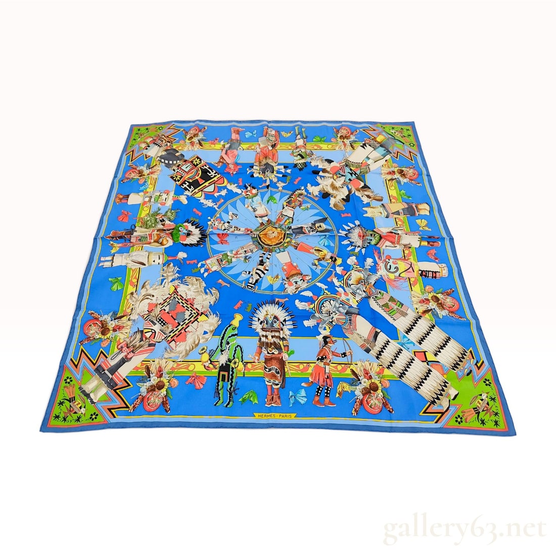 Hermes Kachinas Silk Scarf by Kermit Oliver: Hermes silk twill scarf in the Kachinas pattern, designed by Kermit Oliver. The composition features a central sun-like shield surrounded by a circular array of Hopi Kachina dolls identified by indivi
