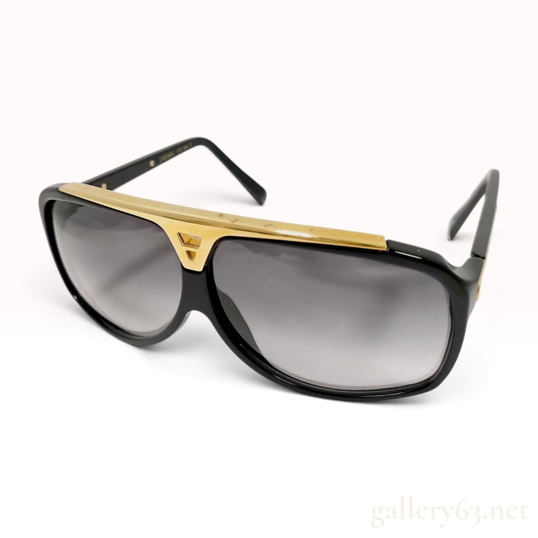 Louis Vuitton Evidence Black Acetate and Gold Tone Monogram Sunglasses Z0350E: A pair of Louis Vuitton Evidence sunglasses, model Z0350E. These aviator-style sunglasses are constructed with black acetate frames and feature gradient grey lenses. A prominent gold-tone metal bar sp
