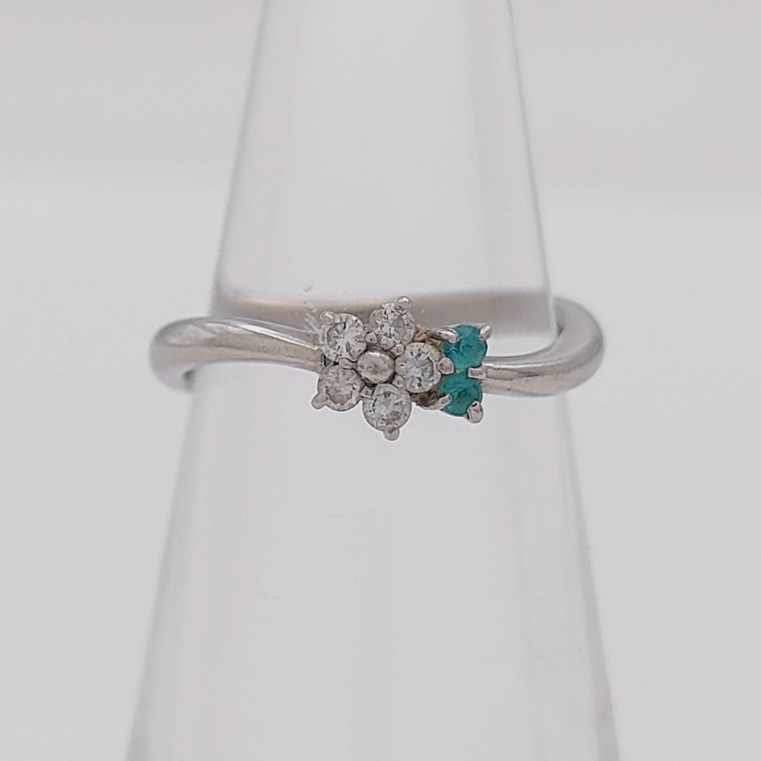 Platinum 0.10ct Natural Diamond and Paraiba Tourmaline Floral Bypass Ring: This item is in excellent pre-owned condition. A platinum ring featuring a bypass shank that terminates in a floral cluster motif. The design centers on a flower head composed of six round brilliant-c