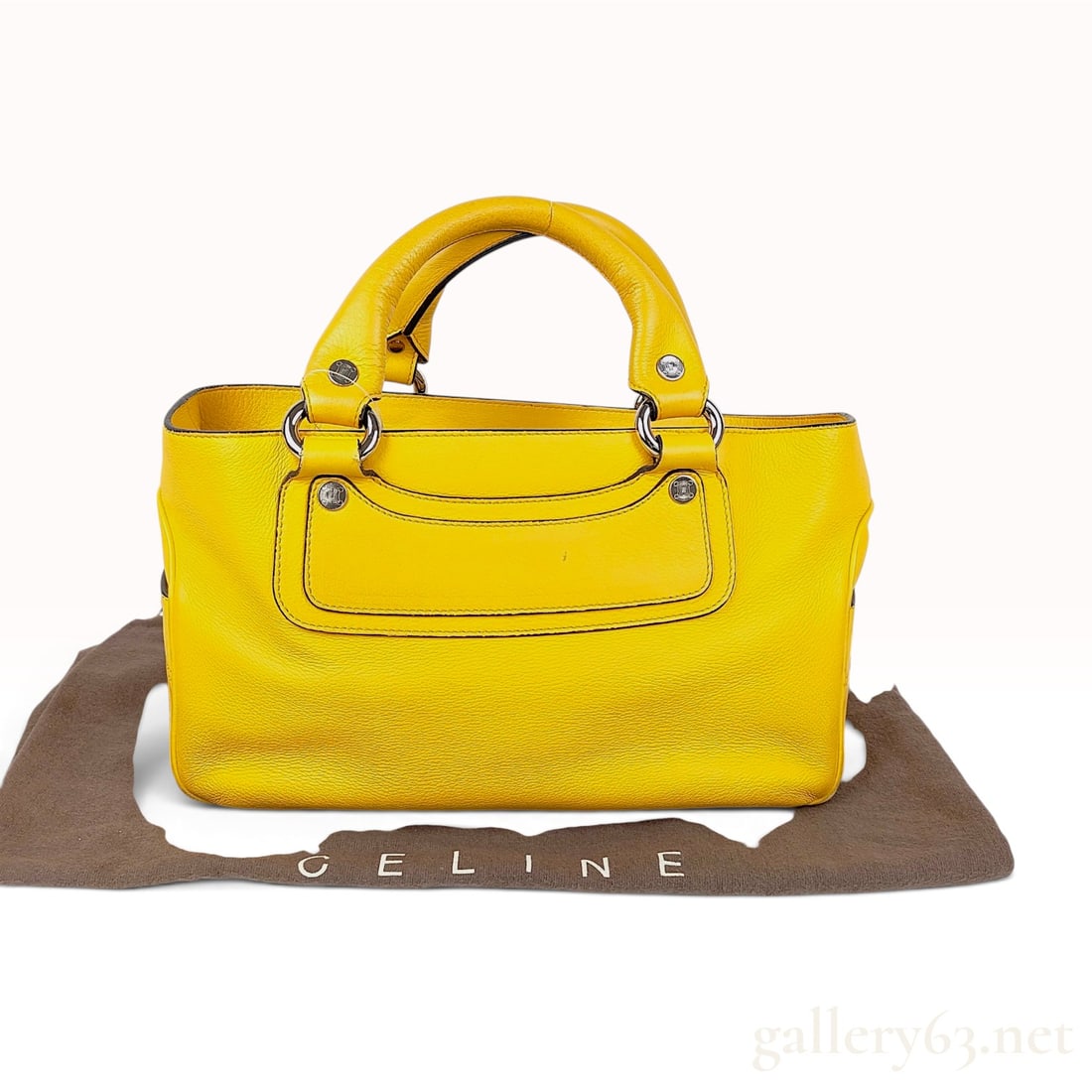 Celine Grained Yellow Leather Boogie Bag: This Celine Boogie handbag is constructed from grained yellow leather and features a satchel silhouette with two exterior side slip pockets and a single front slip pocket. The bag is equipped with dou