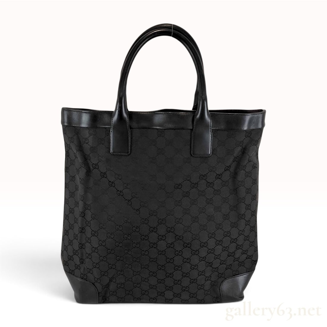 Gucci GG Monogram Canvas and Leather Large Tote Bag: A large Gucci tote bag constructed from black GG monogram canvas with black leather trim and handles. The bag features a black leather top border and two rolled leather handles. The base is reinforced