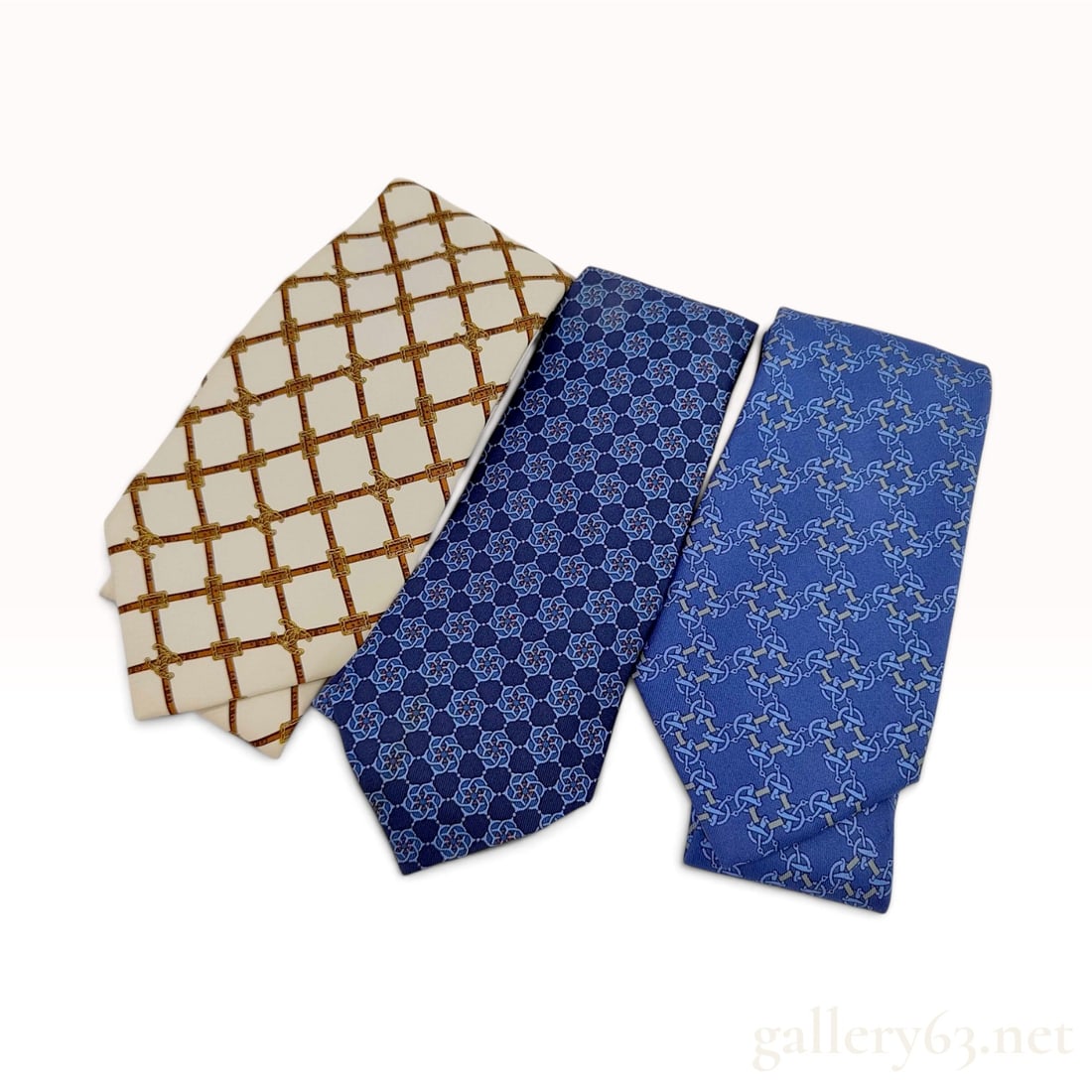 A Trio of Luxury Silk Neckties by Chanel and Hermes: This lot features three luxury silk neckties from the French fashion houses Chanel and Hermes. The first tie is a Chanel necktie crafted in Italy from 100 percent silk. The design consists of a cream 