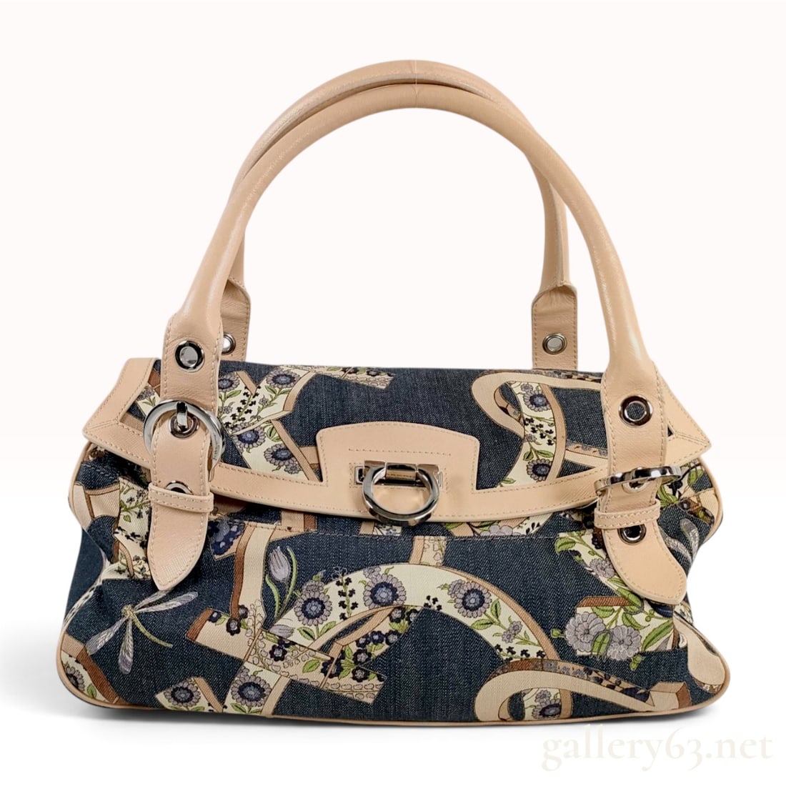 Salvatore Ferragamo Gancini Floral Print Denim and Leather Satchel: A Salvatore Ferragamo satchel featuring a blue denim canvas exterior decorated with a multi-color floral and scroll print in tan, green, and purple. The bag is accented with tan cross-hatch leather