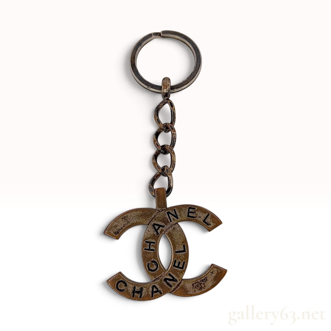 Chanel Gold-Tone Spring 1998 CC Logo Keychain: This authentic Chanel keychain is from the Spring 1998 collection. The accessory is crafted from gold-tone metal and features a split key ring attached to a four-link chain, terminating in a large int