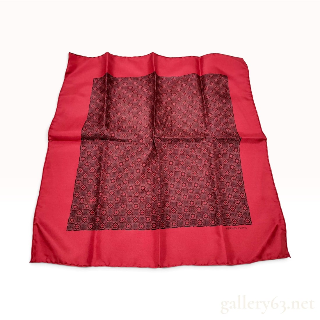 Hermes Silk Twill Pocket Square with Red and Black Geometric Motif: A vintage silk twill pocket square by Hermes, Paris. The item features a vibrant red ground with a large central rectangular panel containing a repeating black geometric floral medallion motif. The pi