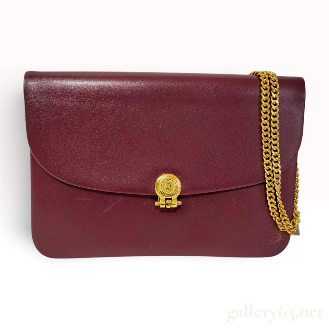 Christian Dior Vintage Burgundy Leather Chain Flap Shoulder Bag: Christian Dior vintage shoulder bag crafted from smooth burgundy leather. The structured rectangular bag features a front flap secured by a gold-tone circular medallion clasp embossed with a stylized 