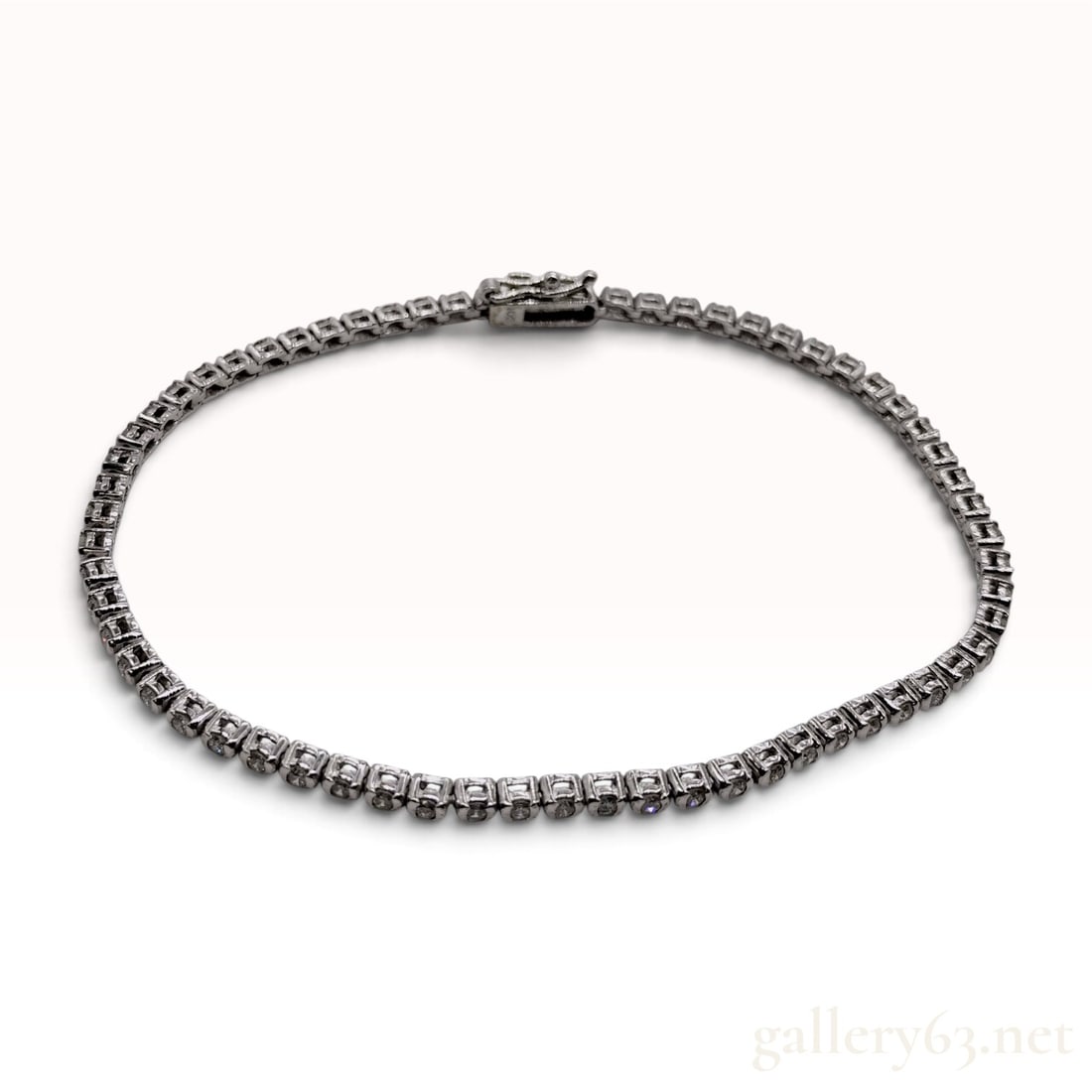 14 Karat White Gold and 1.03 Carat Diamond Tennis Bracelet: A 14 karat white gold tennis bracelet featuring a linear series of round brilliant-cut diamonds. Each diamond is secured within an individual semi-bezel setting, forming the links of the bracelet. The