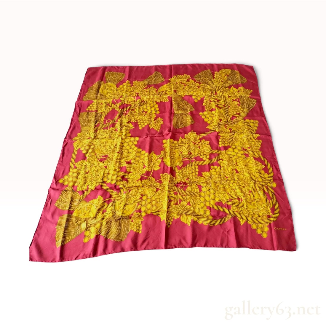 Chanel CC Logo Grape and Tassel Motif Silk Scarf: A vintage silk square scarf by Chanel featuring a large-scale botanical and ornamental motif. The design is set against a vibrant magenta pink ground and showcases golden clusters of grapes, vine leav