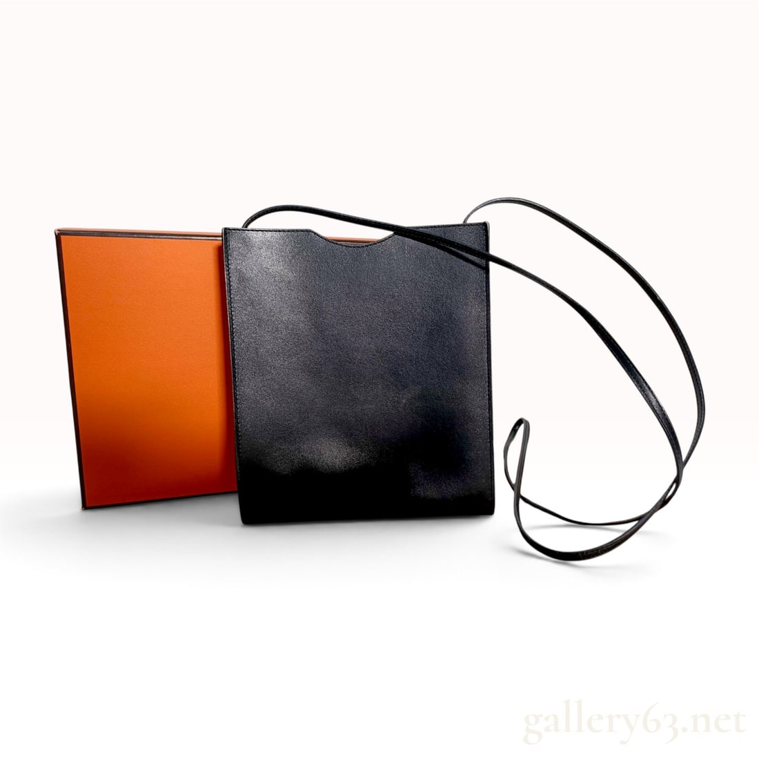 Hermes Black Box Calf Onimaitou Crossbody Bag with Box: Hermes Onimaitou crossbody bag crafted from smooth black box calf leather. This minimalist design features a slim rectangular silhouette with a distinctive curved cutout at the top opening. The bag is