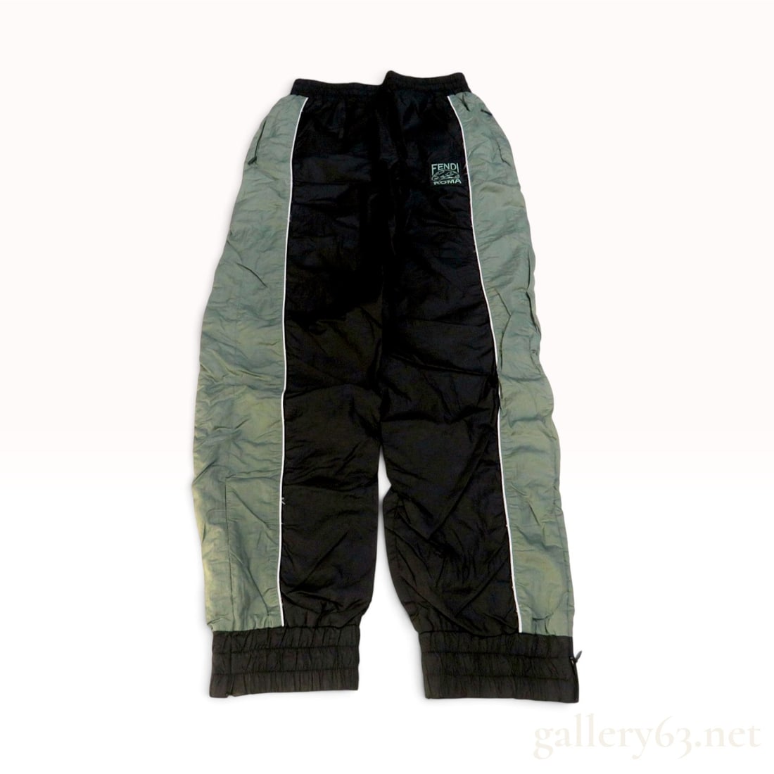 Fendi Color Blocked Nylon Track Pants Size XS: These Fendi track pants are crafted from a 100 percent polyamide outer shell with a 100 percent cotton lining. The garment features a color-blocked design in black and sage green, accented by thin whi