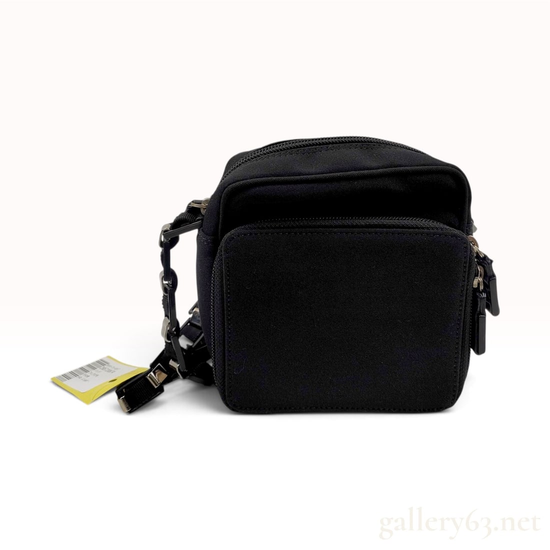 Salvatore Ferragamo Black Nylon Small Crossbody Camera Bag: A small crossbody camera bag produced by Salvatore Ferragamo, featuring a black nylon exterior and a branded jacquard textile lining. The design includes a main zippered compartment and a smaller fron