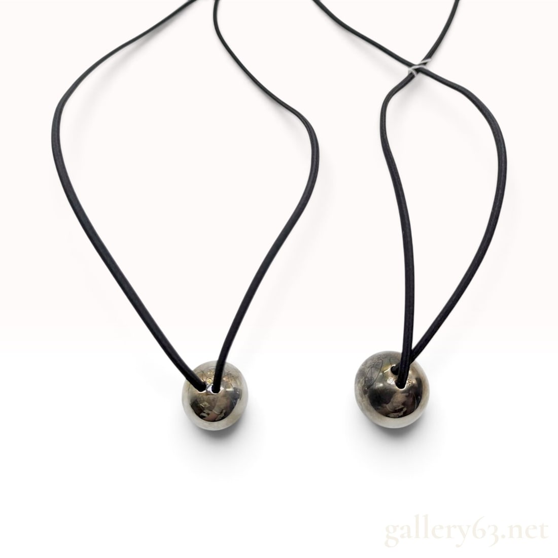 Chanel Sterling Silver Ball Pendant Cord Necklace: A Chanel necklace featuring two spherical pendants with flattened bases. The pendants are constructed from solid sterling silver and are threaded onto a continuous loop of black fabric-covered elastic