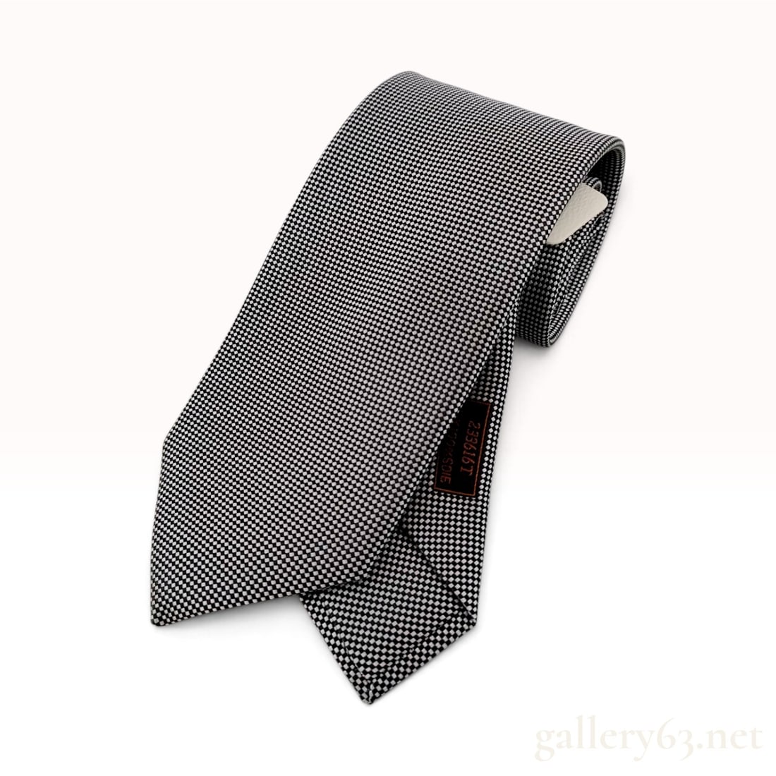 Hermes Black and White Micro-Check Silk Tie with Original Box and Tags: A 100% silk necktie by Hermes featuring a monochromatic black and white micro-checkerboard pattern. The tie is constructed from high-quality woven silk and features multiple identifying labels. The si