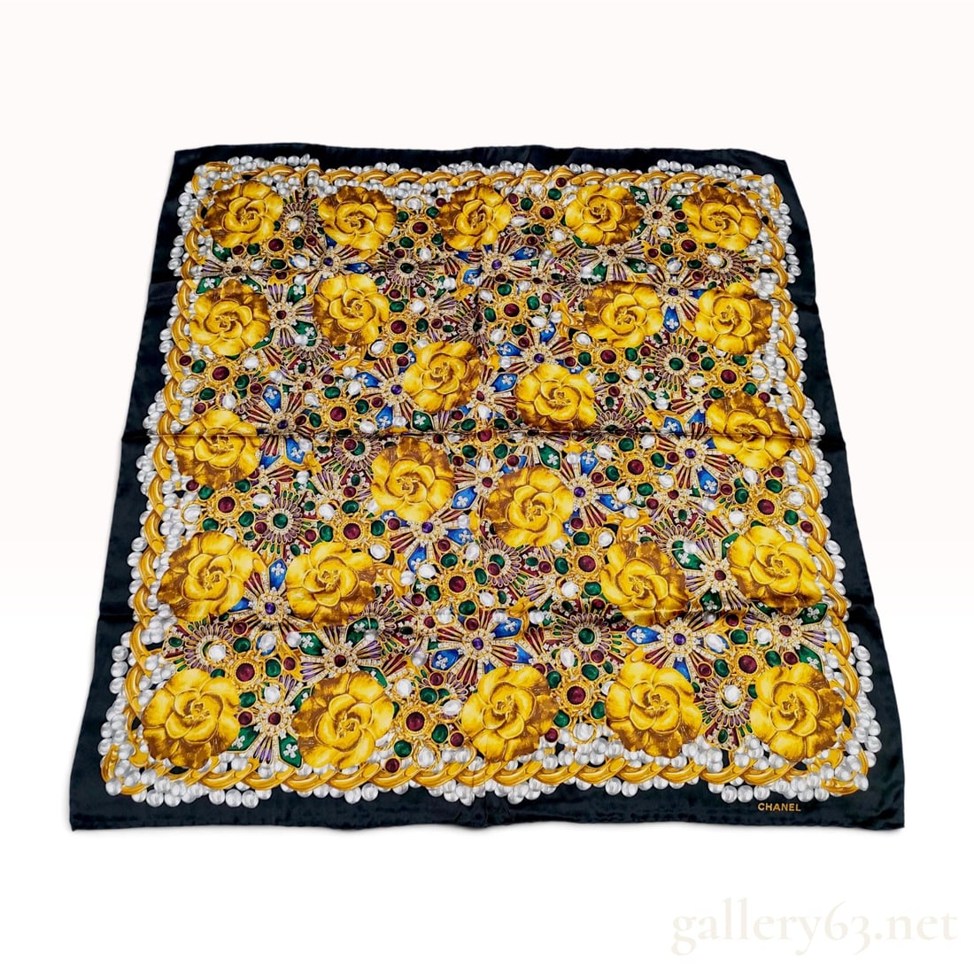 Chanel Camellia and Jewelry Motif Silk Scarf: A large square silk scarf by Chanel featuring an ornate and dense pattern of golden camellia blossoms and jeweled medallions. The design includes medallions set with red, green, and purple faceted sto