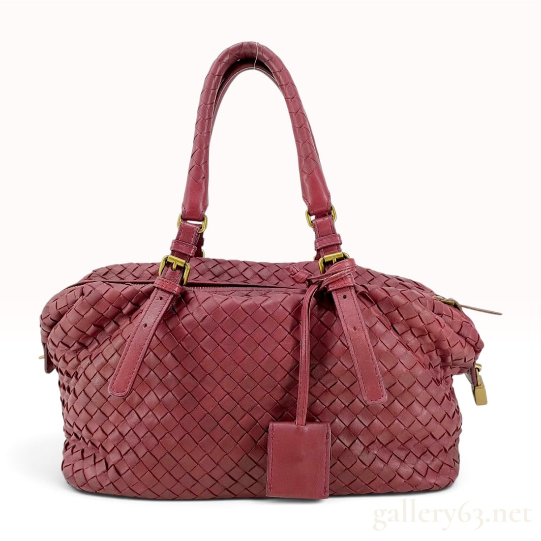 Bottega Veneta Burgundy Intrecciato Leather Montaigne Satchel: This Bottega Veneta Montaigne satchel is constructed from burgundy nappa leather in the signature Intrecciato hand-woven pattern. The bag features dual adjustable flat top handles with antiqued