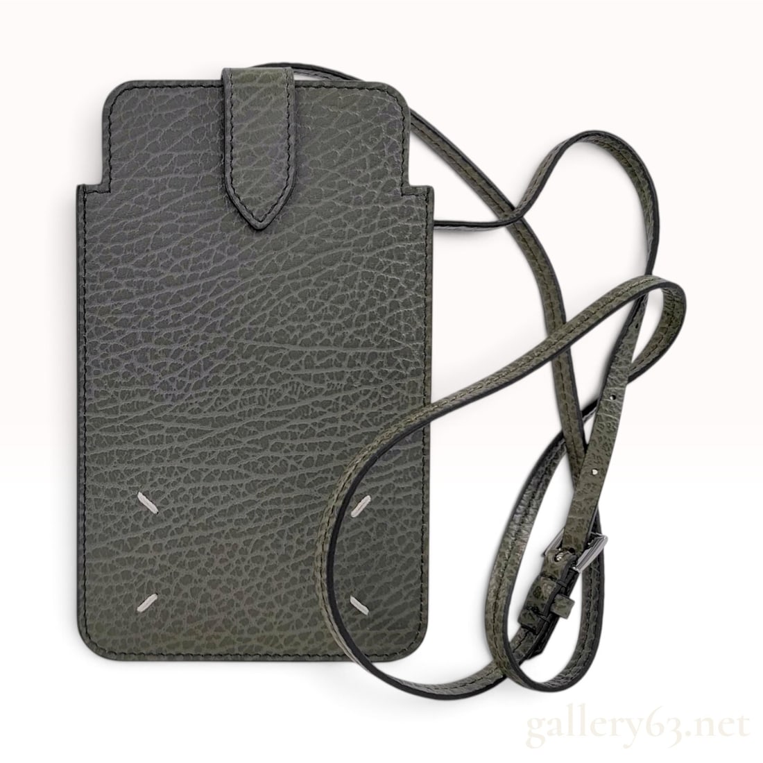 Maison Margiela Grained Leather Phone Pouch with Crossbody Strap: A Maison Margiela mobile phone pouch crafted from gray-green grained leather. The design features a slim, rectangular profile with a protective top flap and an integrated, adjustable shoulder strap fi