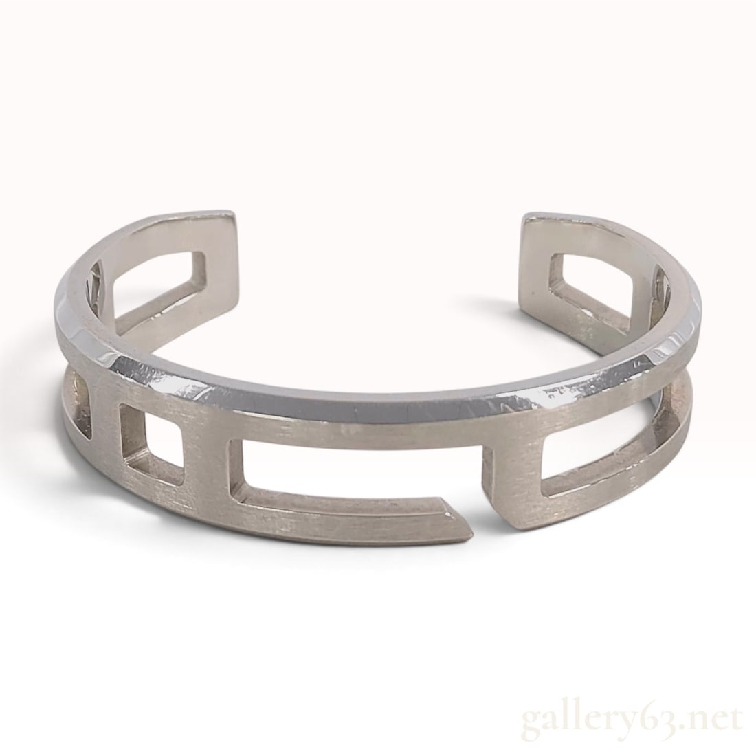 Hermes Play Bangle Solid 925 Sterling Silver Cuff Bracelet: An Hermes Play Bangle composed of solid 925 sterling silver. The bracelet features an openwork cuff design with geometric rectangular and square cutouts forming a stylized motif. The exterior surface 