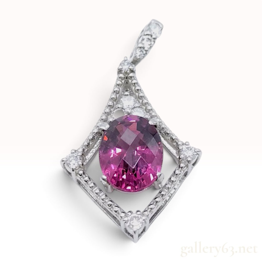 Platinum Pinkish Purple Tourmaline and Diamond Pendant: A platinum pendant featuring a central oval-cut pinkish purple tourmaline weighing 2.52 carats. The gemstone is held in a four-prong mount within an openwork rhombus-shaped frame. The frame is embelli