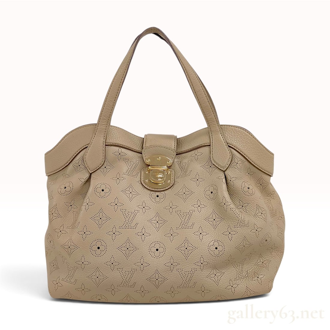 Louis Vuitton Mahina XL Perforated Leather Tote Bag in Taupe: This Louis Vuitton Mahina XL tote is constructed from taupe perforated calfskin leather featuring the signature Monogram pattern. The bag has a slouchy silhouette with side buckles and a top front lea