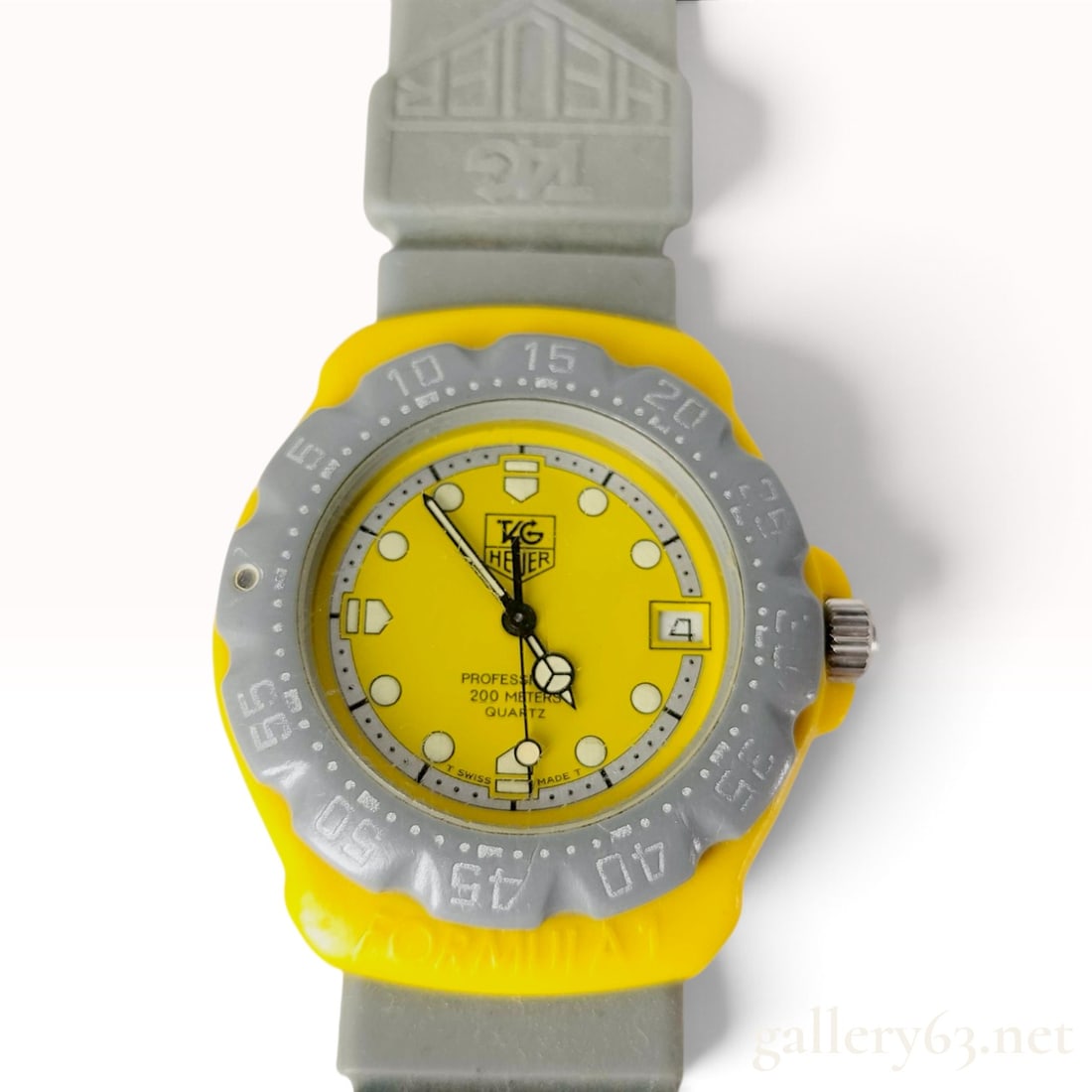 TAG Heuer Formula 1 Wristwatch Reference 382.513/1: This is a vintage first-generation TAG Heuer Formula 1 wristwatch, reference number 382.513/1. The timepiece features a bright yellow synthetic resin case with a gray plastic unidirectional rotating b