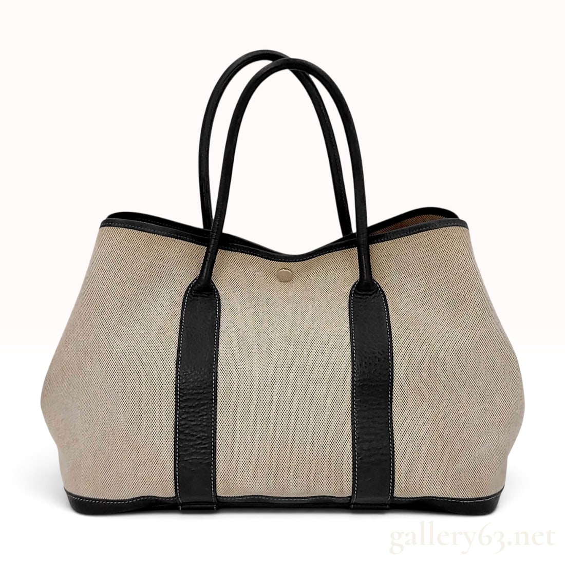 Hermes Garden Party 36 Ecru Toile and Noir Negonda Leather Tote Bag: This Hermes Garden Party 36 tote bag features an ecru toile canvas body with noir Negonda leather trim, base, and handles. The bag is constructed with a structured leather bottom and vertical leather 