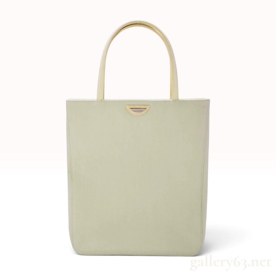 Christian Dior Ivory Woven Canvas and Patent Leather Vertical Tote Bag: This Christian Dior vertical tote bag is constructed from a textured ivory woven canvas body with cream patent leather top handles and trim. The front is accented with a silver-tone metal plate emboss