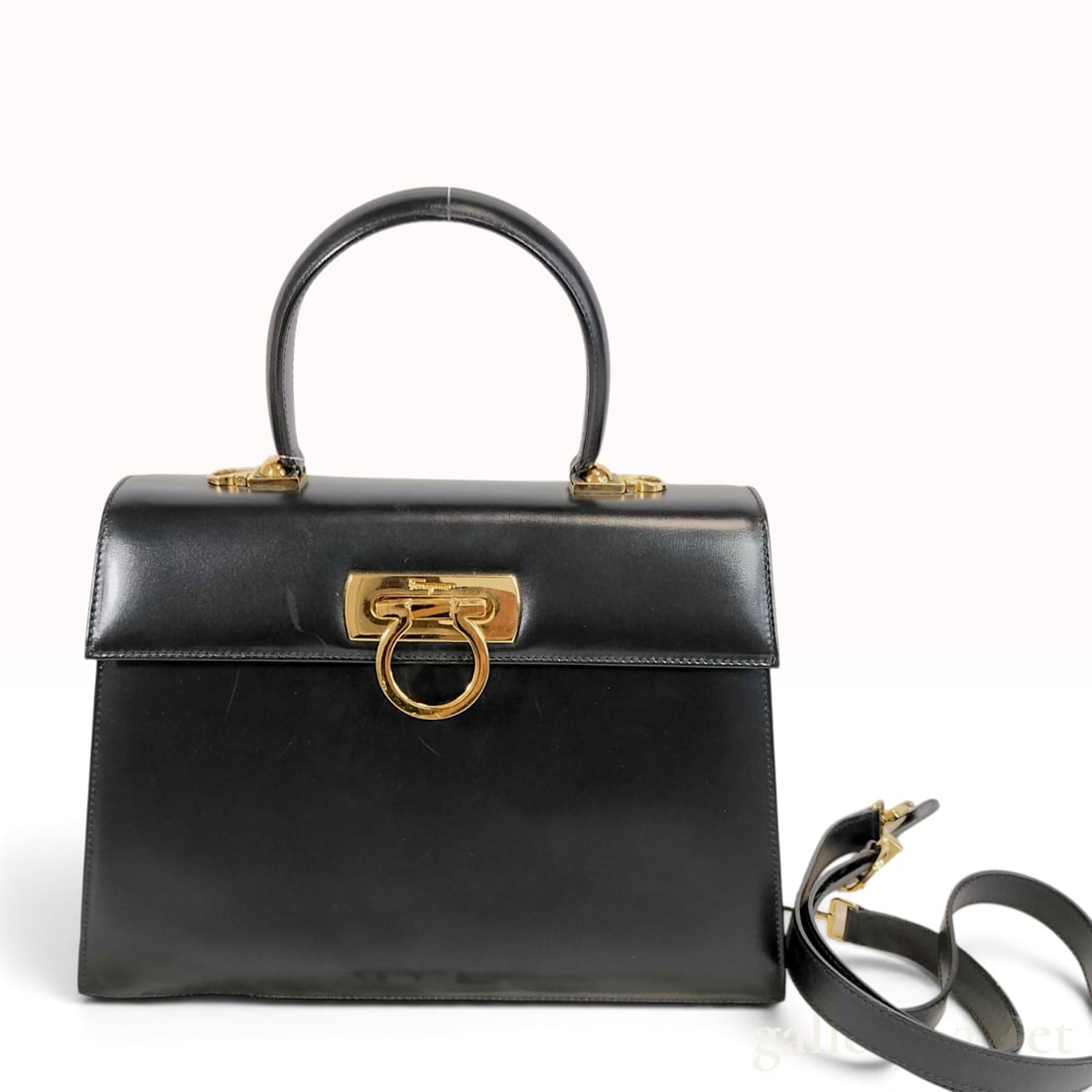 Salvatore Ferragamo Black Leather Gancini Top Handle Bag: A Salvatore Ferragamo structured top-handle handbag, commonly known as the Gancini 2-way bag. The exterior is crafted from smooth black calfskin leather and features a single rolled leather top handle