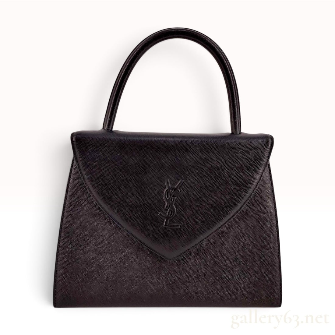 Yves Saint Laurent Vintage Black Saffiano Leather Top Handle Bag: A vintage structured handbag by Yves Saint Laurent, crafted from black Saffiano leather with a cross-hatched grain finish. The bag features a trapezoidal silhouette with a single rolled top handle and
