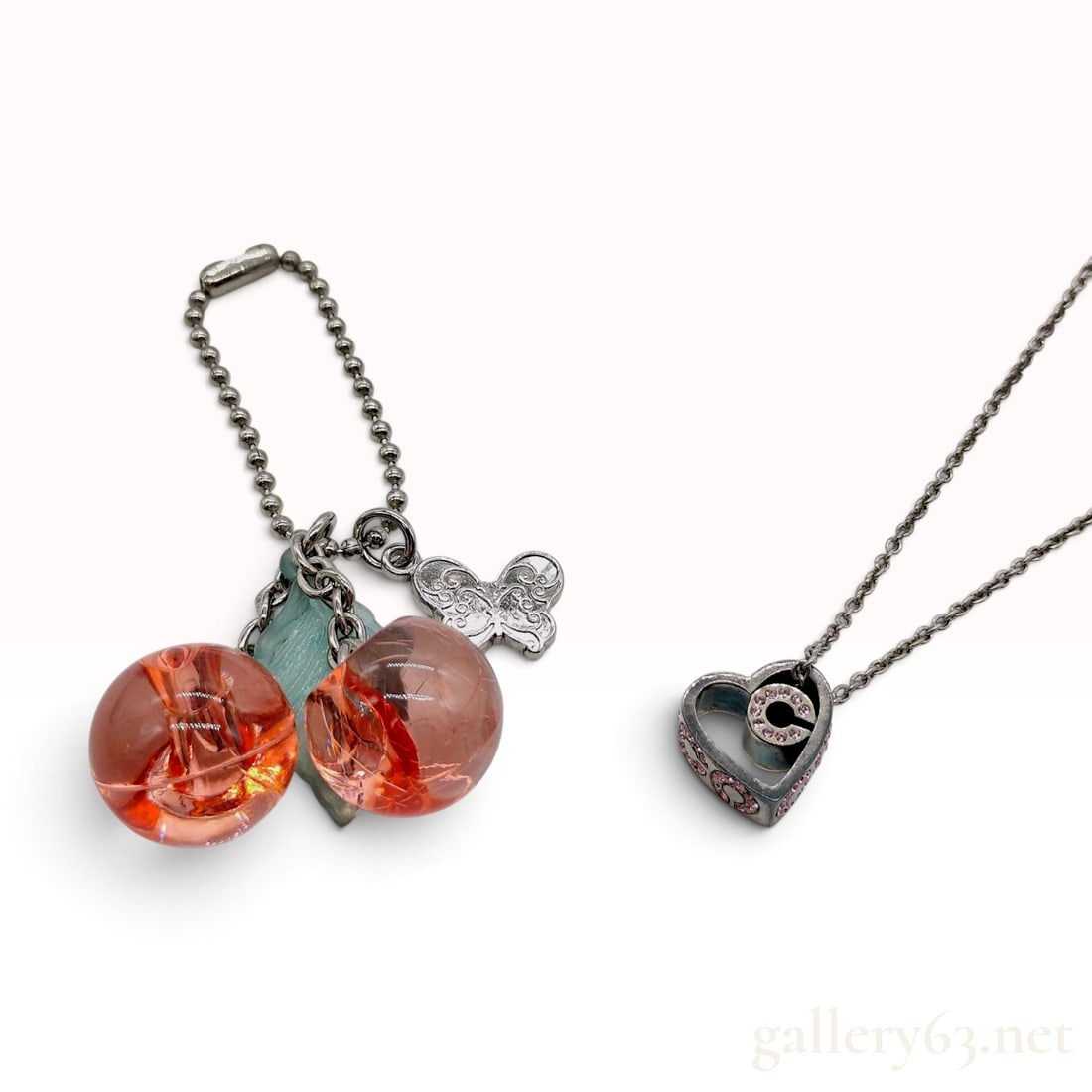 Coach 925 Sterling Silver Heart Pendant Necklace and Fashion Jewelry Trio: This Coach pendant necklace is crafted from 925 sterling silver and features a heart-shaped frame accented with pink rhinestones. The exterior sides of the heart are decorated with circular C patterns