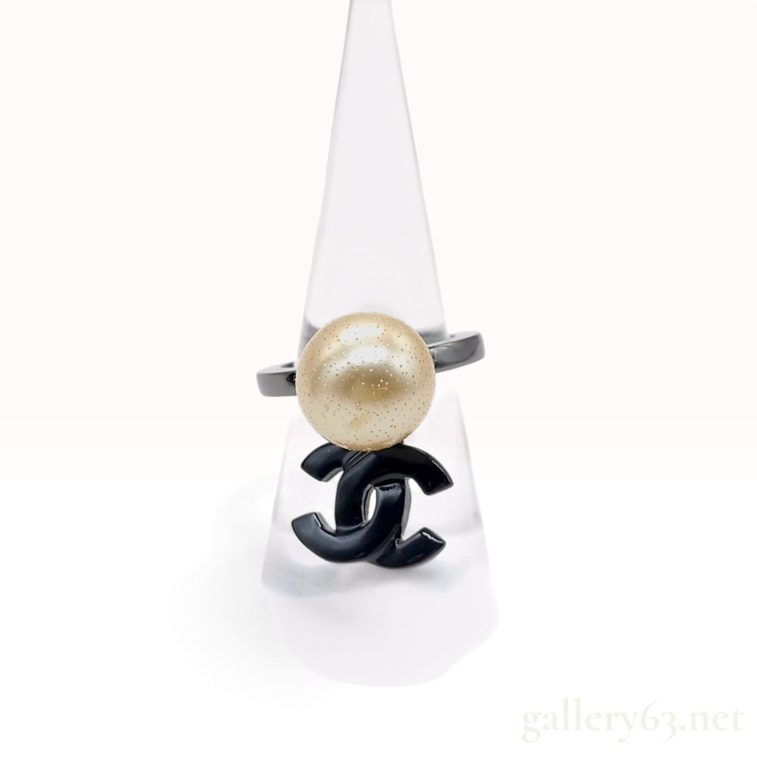 Chanel Oversized Faux Pearl and CC Logo Gunmetal Ring with Box: This is a Chanel fashion cocktail ring featuring a dark gunmetal-finish metal band. The ring is topped with an oversized spherical faux pearl bead, which is finished with a hammered and textured gold-