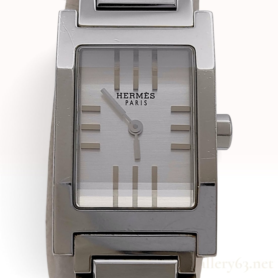 Hermes Tandem Stainless Steel Ladies Wristwatch: This Hermes Tandem ladies wristwatch is crafted from polished stainless steel. The timepiece features a signature H-shaped case and a silver-tone dial with a multi-tonal vertical striped guilloche pat