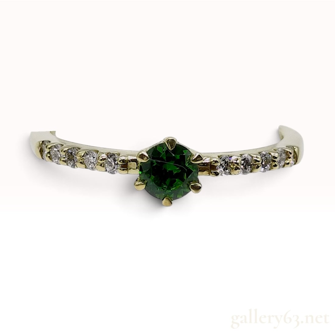 18 Karat Yellow Gold 0.26ct Demantoid Garnet and 0.12ctw Natural Diamond Ring Size 6.75: This 18 karat yellow gold ring features a central round-cut 0.26ct demantoid garnet secured in a traditional six-prong setting. The forest green gemstone is accented by twelve round-cut natural diamon